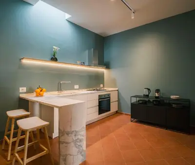 a kitchen with a sink and a counter with stools at LeSicilien - Fior di Sicilia - Apartment with Terrace in Palermo