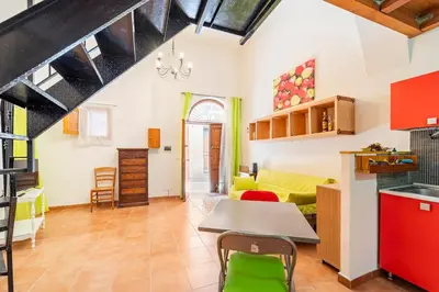 a kitchen and living room with a table and chairs at La petite Bastet in Palermo
