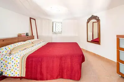 a bedroom with a large bed with a red blanket at La petite Bastet in Palermo