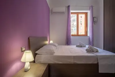 a bedroom with a bed with purple walls and a window at 15 min to Historic Center, 5 min to Bus, Balcony in Palermo