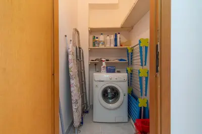 a laundry room with a washing machine and shelves at 15 min to Historic Center, 5 min to Bus, Balcony in Palermo