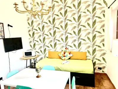 a room with a bed and a wall with a wallpaper at Via del Bosco Home in Palermo