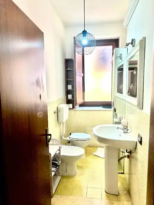 a bathroom with a white toilet and a sink at Via del Bosco Home in Palermo