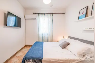 a bedroom with a bed and a tv on the wall at Villa Ametista in Alcamo