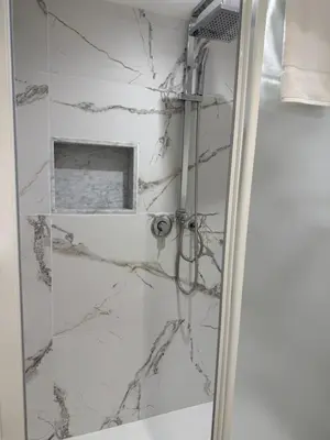 a bathroom with a shower with marble walls at Vittorio Emanuele Suites&Apartments in Palermo