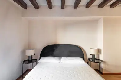 a bedroom with a bed and a table and a chair at Vittorio Emanuele Suites&Apartments in Palermo