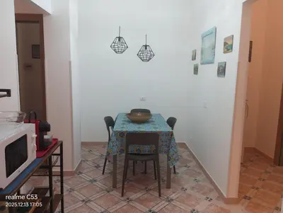 a dining room with a table and chairs and a television at Casa Claudia in Palermo