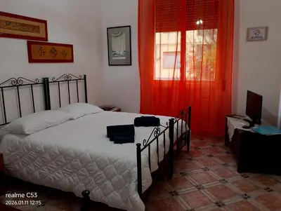 a bedroom with a bed and a window with red curtains at Casa Claudia in Palermo