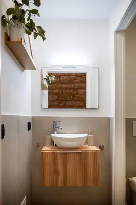 a bathroom with a sink on a wooden stand with a plant at Lo Storico Apartment in Palermo