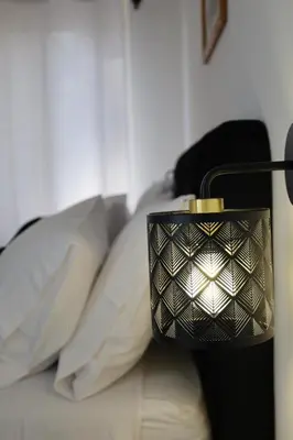 a lamp sitting on top of a bed with pillows at Tolo Tolo Apartaments in Palermo