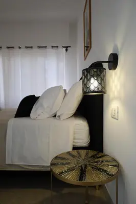 a room with a bed with a table and a lamp at Tolo Tolo Apartaments in Palermo