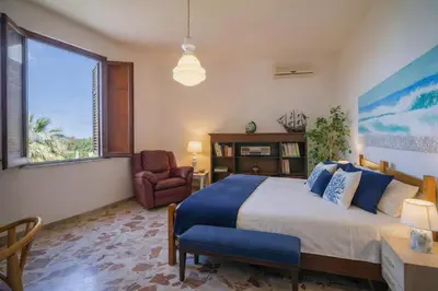 a balcony with a table and a kitchen with a view of the ocean at LeSicilien - Tilde Sunset Bay Villa in Carini