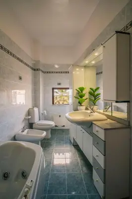a kitchen with wooden cabinets and a table and chairs at LeSicilien - Tilde Sunset Bay Villa in Carini