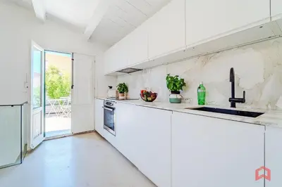 a white kitchen with a sink and a counter at Incantevole Appartamento nel cuore di Palermo in Palermo