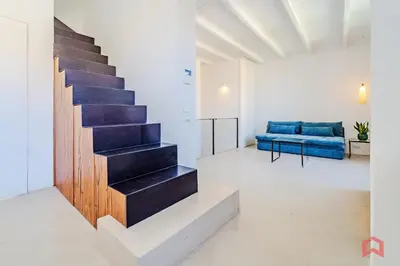 a staircase in a white room with a blue couch at Incantevole Appartamento nel cuore di Palermo in Palermo