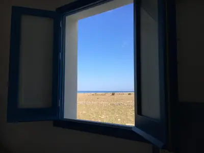 an open window with a view of a field at Le case di Palma in San Vito lo Capo
