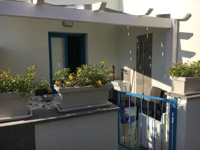 a balcony with potted plants on the side of a building at Le case di Palma in San Vito lo Capo