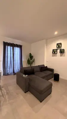 a living room with a brown couch and a table at CR Home in Palermo