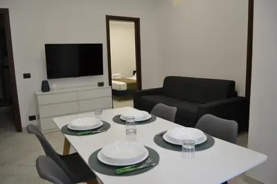 a living room with a white table and chairs at VitaNova Apartment in Palermo
