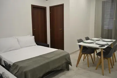 a bedroom with a bed and a table and chairs at VitaNova Apartment in Palermo