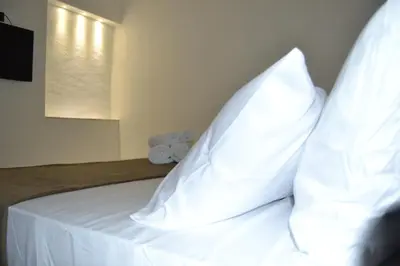 a bed with white sheets and pillows on it at VitaNova Apartment in Palermo