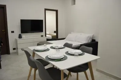 a living room with a white table and chairs at VitaNova Apartment in Palermo