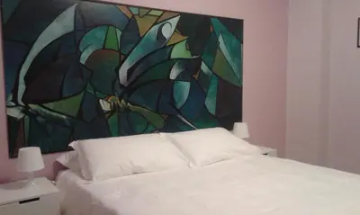 a bedroom with a bed with a painting on the wall at B&b Bagheria in Bagheria