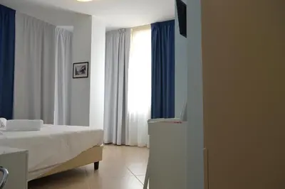a bedroom with a bed and a window with a television at B&b Bagheria in Bagheria