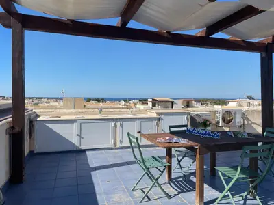 a patio with a table and chairs on a roof at Casa Sterlizia by Holiday World in San Vito lo Capo