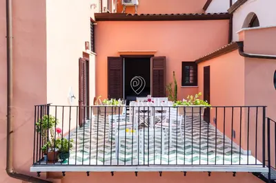 a balcony with a table and plants on it at Elegante palazzo storico con splendida vista mare in Castellammare del Golfo