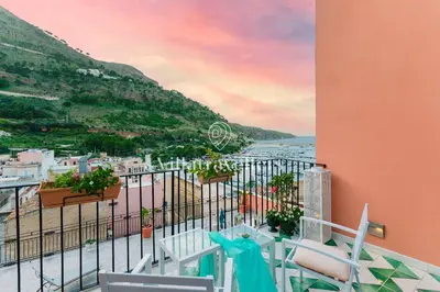 a balcony with chairs and a view of the ocean at Elegante palazzo storico con splendida vista mare in Castellammare del Golfo