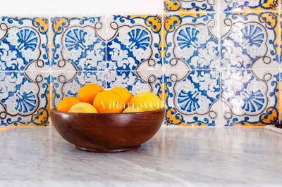 a wooden bowl of oranges sitting on a table at Elegante palazzo storico con splendida vista mare in Castellammare del Golfo