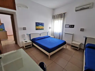 a bedroom with a bed with a blue comforter at Case d'estate Mondello in Palermo
