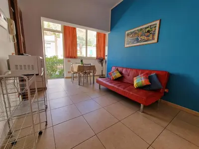 a living room with a red couch and a blue wall at Case d'estate Mondello in Palermo