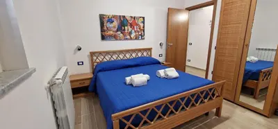 a bedroom with a blue bed with towels on it at Casa Fortuna Mondello in Palermo
