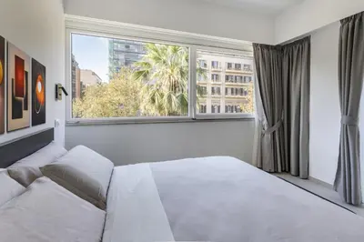 a bedroom with a white bed and a large window at Case libertà in Palermo
