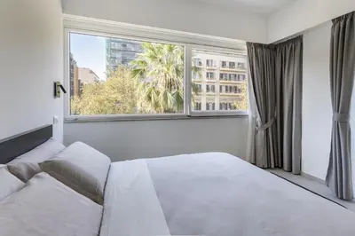 a bedroom with a white bed and a large window at Case libertà in Palermo