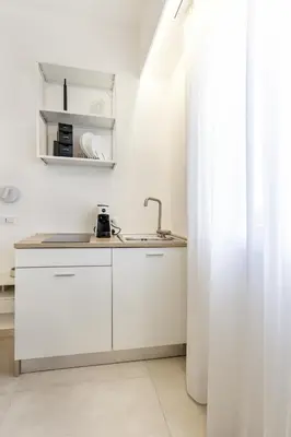 a kitchen with white cabinets and a sink at Case libertà in Palermo
