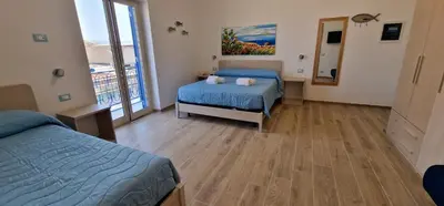 a hotel room with two beds and a mirror at Casa Elisa in Palermo