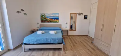 a bedroom with a bed and a painting on the wall at Casa Elisa in Palermo