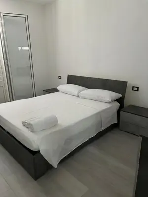 a bedroom with a large bed with white sheets and pillows at BALISTRERI HOUSe in Trabia