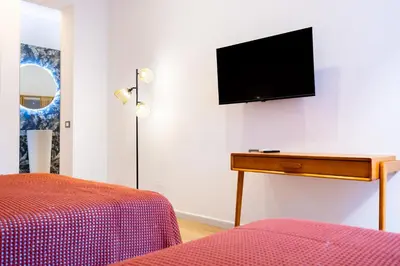 a bedroom with a bed and a television on a wall at Rosalia e le altre in Palermo