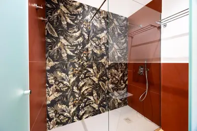 a shower stall with a black and white patterned wall at Rosalia e le altre in Palermo