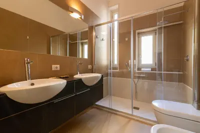 a bathroom with two sinks and a glass shower at GuestHost - Palermo Roomy and Modern Apartment in Palermo