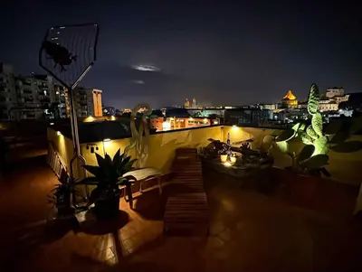 a balcony with a view of a city at night at Terrace in the Sky overlooking Historic Center in Palermo