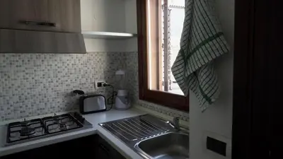 a kitchen with a sink and a stove and a window at Casa Amuri in Palermo