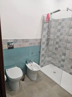 a bathroom with a toilet and a shower and a sink at Court Holiday - La casa del Giudice in Palermo