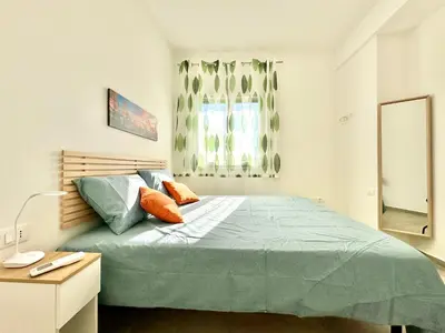 a bedroom with a large bed and a window at Zàgave Apartment a 200 mt dal mare in Alcamo