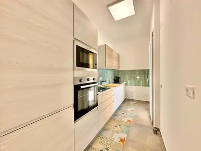 a kitchen with a stove and a microwave at Zàgave Apartment a 200 mt dal mare in Alcamo