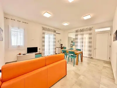 a living room with an orange couch and a table at Zàgave Apartment a 200 mt dal mare in Alcamo